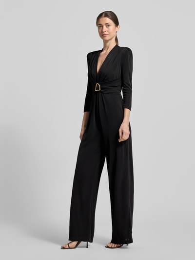 Vrouwenmodel draagt Regular Fit Jumpsuit mit Zierbesatz van Rinascimento in zwart, V-hals, sierdetail, elastische stof, lange mouwen, getailleerde pasvorm, plooi-effect, full body vooraanzicht.