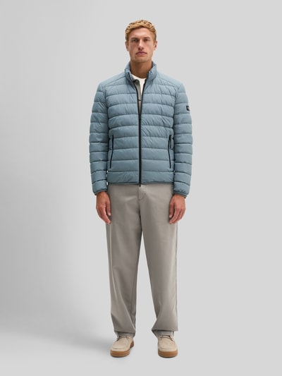 Männermodel trägt Regular Fit Steppjacke mit Zweiwege-Reißverschluss von Marc O'Polo in Hellblau mit glatter Textur, Ganzkörperansicht von vorne. Herren Steppjacke von Marc O'Polo