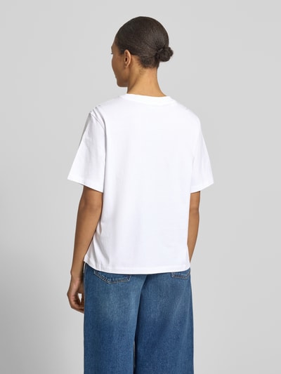 Frauenmodel trägt Regular Fit T-Shirt aus reiner Baumwolle Modell 'MACY' von Selected Femme, jednokolorowy, dżersej, okrągły dekolt, z napisem z logo, krótki rękaw, damski t-shirt, Ganzkörperansicht Rückansicht