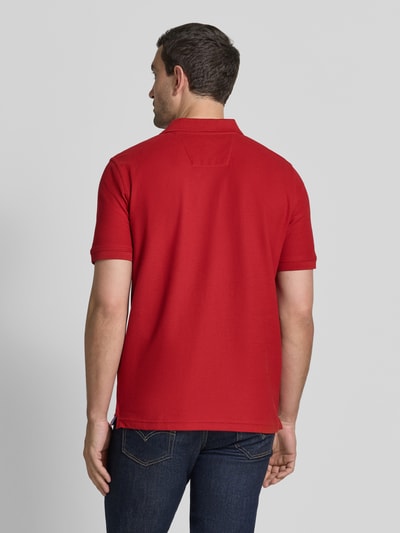 Männermodel trägt Regular Fit Poloshirt mit Label-Stitching von Fynch-Hatton in Rot aus Reine Baumwolle, Rückenansicht, Rückenlänge 72 cm bei Größe M.