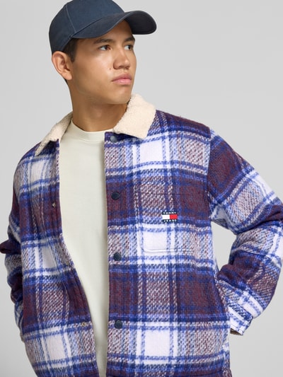 Männermodel trägt Oversized Hemdjacke mit Umlegekragen Modell 'TEDDY COLLAR BRUSHED' von Tommy Jeans, kariertes Muster, Ganzkörperansicht von vorne, Herren Hemdjacke von Tommy Jeans.