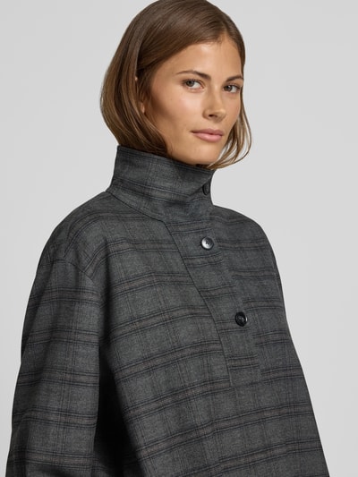 Frauenmodel trägt Bluse mit Stehkragen und kurzer Knopfleiste von Style Icon Collection, kariertes Grau, Loose Fit, Nahaufnahme Oberkörper.