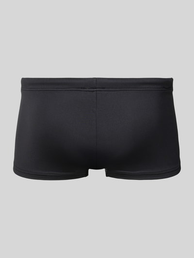 Produktfoto, schwarze Badehose mit Label-Patch von Emporio Armani, elastischer Bund, Trunk Fit, glatte Struktur, Rückansicht.