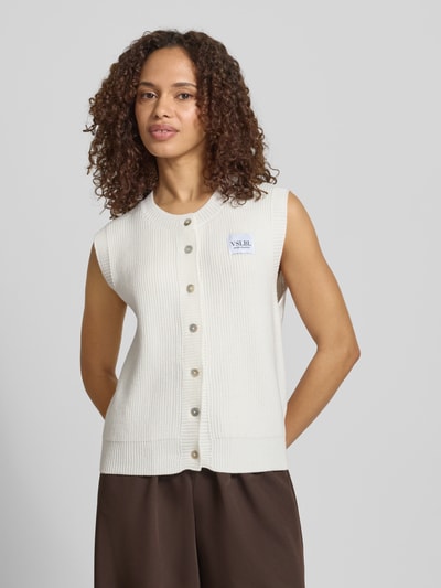 Vrouwenmodel draagt Regular Fit mouwloos vest uit viscosemix model 'MILLA' van VILLA SOPHIE, effen look, ribtricot, labelpatch, knoopsluiting, ronde hals, rompzoom geribd, detailopname bovenlichaam.