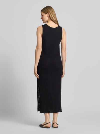 Frauenmodel trägt Maxikleid mit Rundhalsausschnitt Modell 'ZURI' von JJXX aus Reine Baumwolle, Körpernaher-Schnitt, Rückenlänge 131 cm, Brustweite 45 cm, schwarzer Stoff mit leichter Textur, Ganzkörperansicht Rückansicht.