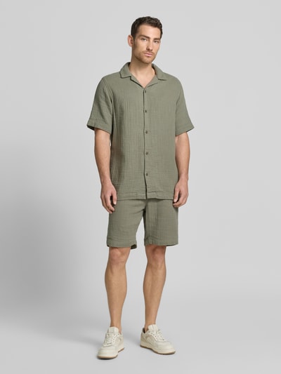Männermodel trägt Relaxed Fit Freizeithemd mit Strukturmuster von Lindbergh aus Reiner Baumwolle, olivgrün, Reverskragen, Knopfleiste, Kurzärmelig, Ganzkörperansicht von vorne.
