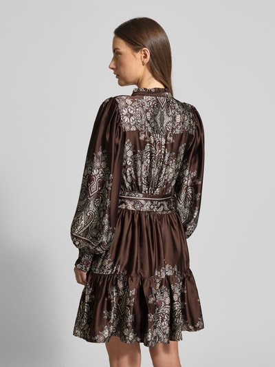 Kobiece modelka nosi sukienkę do kolan z dekoltem w serek model 'MALFIDA' od Neo Noir, taliowany krój, pasek w talii, długość tyłu 92 cm, szerokość klatki piersiowej 43 cm, długość rękawów 64 cm, widok całej sylwetki z tyłu.