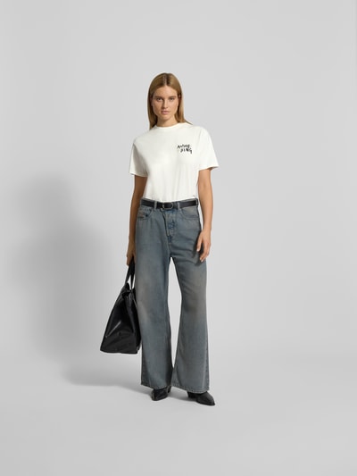 Frauenmodel trägt T-Shirt mit Label-Print von Anine Bing aus Reine Baumwolle, Lockerer-Schnitt, Rundhalsausschnitt, Vorderansicht Ganzkörperansicht.