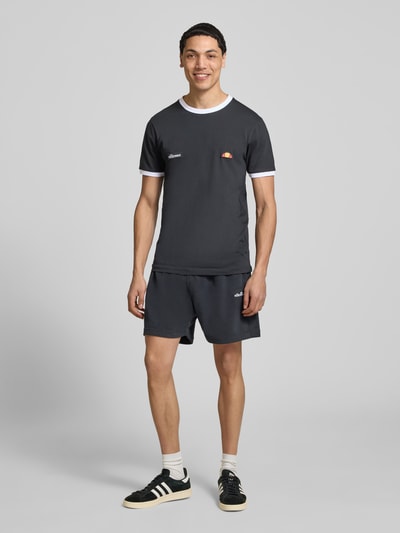 Männermodel trägt Shorts mit Logo-Stitching Modell 'ZANICA' von Ellesse aus Baumwoll-Mix, relaxed Fit, Farbe Dunkelgrau, Ganzkörperansicht von vorne.