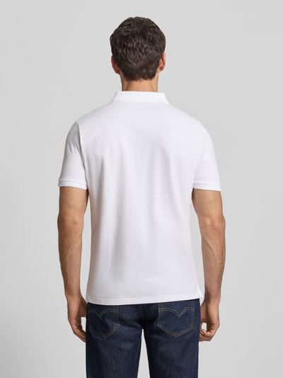 Männermodel trägt Regular Fit Poloshirt mit Logo-Stitching Modell 'BASIC' von Tom Tailor in Optik: Unifarben, Ganzkörperansicht Rückansicht.