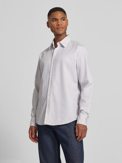 Männermodel trägt Regular Fit Freizeithemd aus Baumwoll-Mix Modell 'RELEGANT_6_M' von BOSS Orange, unifarben, gepunktet, Ganzkörperansicht von vorne.