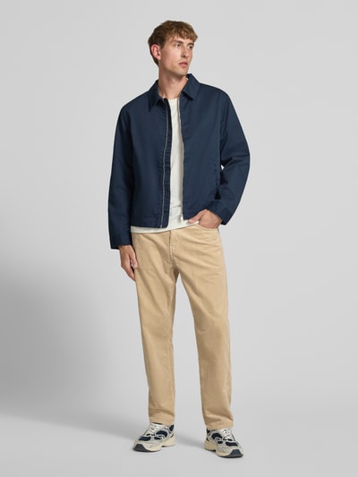 Männermodel trägt Straight Fit Hose aus reiner Baumwolle in Cord-Optik von Carhartt Work In Progress, Beige, 5-Pocket-Design, Ganzkörperansicht von vorne.
