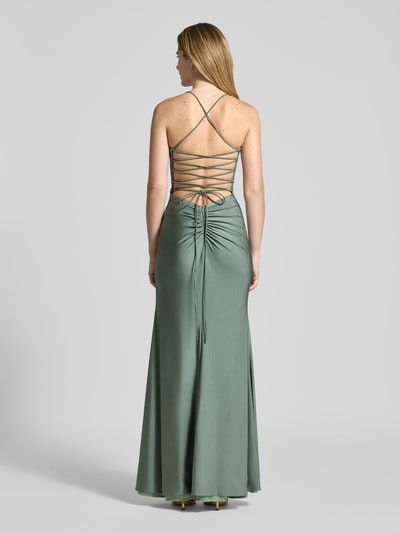 Modelka nosi Abendkleid in Wickel-Optik od Mascara, satynowa zieleń, dopasowany krój slim fit, sercowaty dekolt, marszczenia, maxi, bez rękawów, spaghetti ramiączka, zamek, długość tyłu w rozmiarze 36: 143 cm, szerokość w rozmiarze 36: 38 cm, widok całej sylwetki z tyłu.