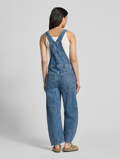 Vrouwenmodel draagt Barrel Fit Denim-tuinbroek met verstelbare bandjes van GAP in puur katoen, met borstzak en twee achterzakken. Ganzkörperansicht Rückansicht. Ruglengte maat S: 47 cm, borstwijdte maat S: 42 cm, totale lengte maat S: 146 cm, binnenbeenlengte maat S: 66 cm.