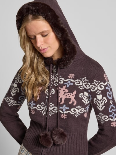 Vrouwenmodel draagt Strickjacke im Allover-Look Modell 'ECLAIR' van DAISY STREET met capuchon en kunstbont, slim fit, pompons, rits, jacquardpatroon in bruin, wit, lila en roze, detailopname bovenlichaam.