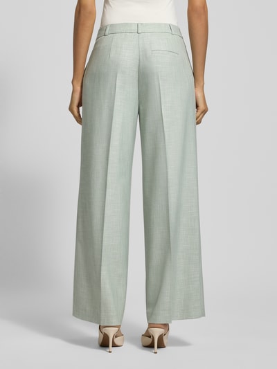 Vrouwenmodel draagt Wide Fit Stoffhose aus Viskose-Mix mit Bügelfalten van comma, lichtgroen, brede pijpen, achterzakken, elastaansch, haken- en ritssluiting, bundwijdte 40 cm, binnenbeenlengte 75 cm, volledige lichaamsopname achteraan.