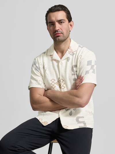 Männermodel trägt Slim Fit Freizeithemd mit Allover-Motiv-Stitching von MCNEAL in Weiß mit bunten Nähten, Reverskragen, Kurzarm, Nahaufnahme Oberkörper.