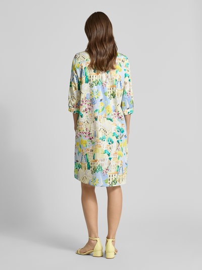 Frauenmodel trägt Knielanges Hemdblusenkleid mit kurzer Knopfleiste von Milano Italy, bunte Muster, reine Baumwolle, 3/4-Arm, Loose Fit, knielang, Rückenlänge 50 cm bei Größe 38, Brustweite 53 cm, Ärmellänge 41 cm, Ganzkörperansicht Rückansicht.