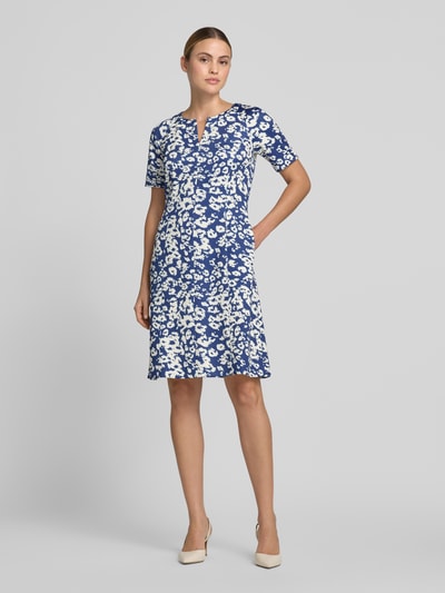 Frauenmodel trägt Knielanges Kleid im Allover-Look mit V-Ausschnitt von Marc Cain, Material-Mix mit Stretch-Anteil, A-Linie, Ganzkörperansicht von vorne.