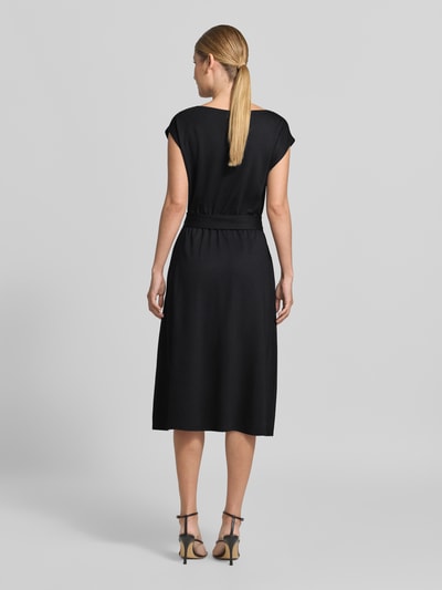 Männermodel trägt schwarzes Relaxed Fit Freizeitkleid aus Viskose-Mix von s.Oliver BLACK LABEL, glatte Struktur, Ganzkörperansicht Rückansicht