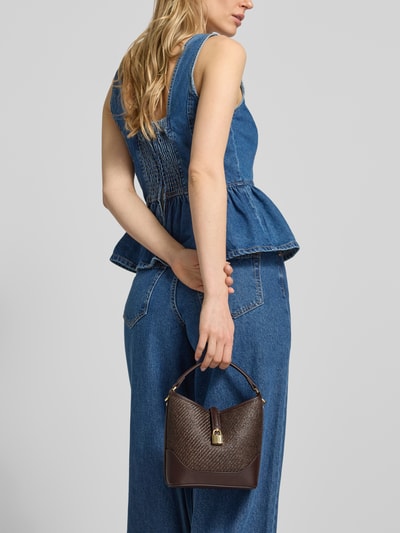 Frauenmodel trägt Umhängetasche mit Tragehenkel von Mango im Material-Mix mit Label-Detail, Hauptfach mit Magnetverschluss, Schulterriemen, Breite 18 cm, Länge 19 cm, Tiefe 10 cm, Länge Schulterriemen 114 cm, Ganzkörperansicht Rückansicht.