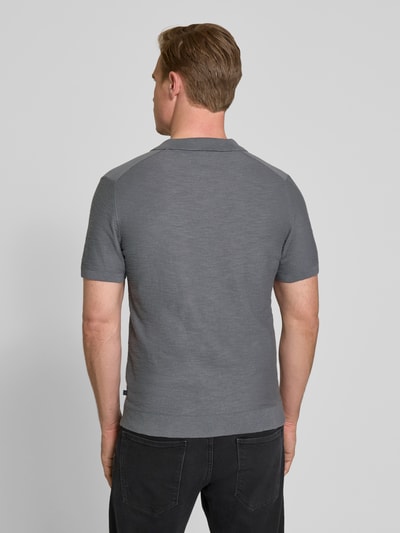 Männermodel trägt Regular Fit Poloshirt aus reiner Baumwolle von s.Oliver RED LABEL, Optik: Unifarben, Strick, Ganzkörperansicht Rückansicht.
