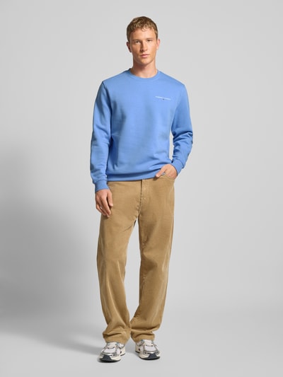 Männermodel trägt Regular Fit Sweatshirt aus Baumwoll-Mix von Tommy Jeans in Optik: Unifarben mit Label-Stitching-Applikation, Rundhals, Langarm, gerippte Ärmel- und Rumpfabschlüsse, Materialverarbeitung: Sweat, Ganzkörperansicht von vorne.