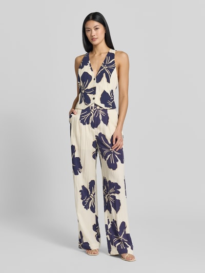 Frauenmodel trägt Stoffhose im Allover-Look Modell 'DOTTER' von MANGO, Lyocell-Viskose-Mix, Wide Leg, florales Muster, Ganzkörperansicht von vorne.