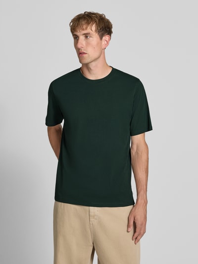 Männermodel trägt t-shirt met ronde hals Model 'ORGANIC' van JACK & JONES in donkergroen, puur katoen, recht model, ruglengte maat M 68 cm, Ganzkörperansicht van voren