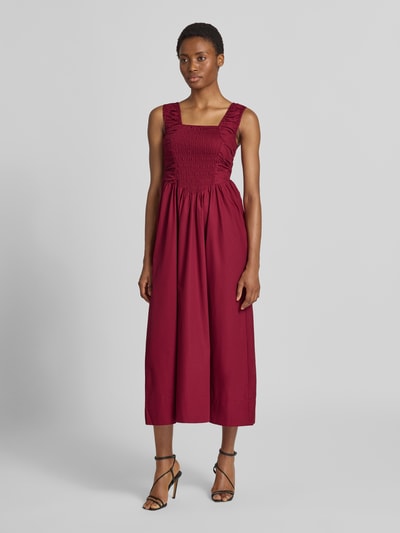 Frauenmodel trägt Cocktailkleid mit Karree-Ausschnitt Modell 'WIMI' von YAS in Bordeaux, reine Baumwolle, A-Linie, Ganzkörperansicht von vorne.