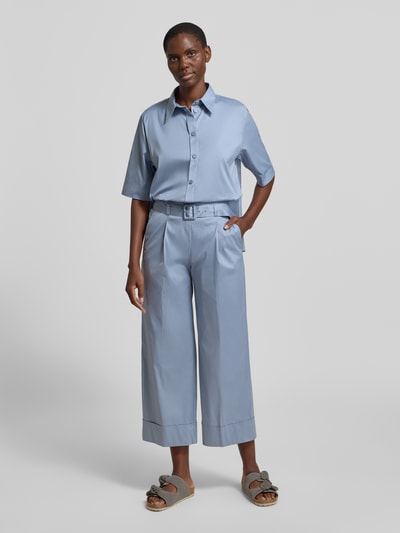Frauenmodel trägt Bluse mit verlängertem Rücken und Kentkragen von Windsor aus Baumwoll-Mix, hellblaue Farbe, Ganzkörperansicht von vorne.