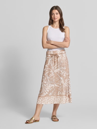 Frauenmodel trägt Midirock im Allover-Look mit Bindegürtel von More & More in Beige und Weiß, A-Linie, Ganzkörperansicht von vorne.