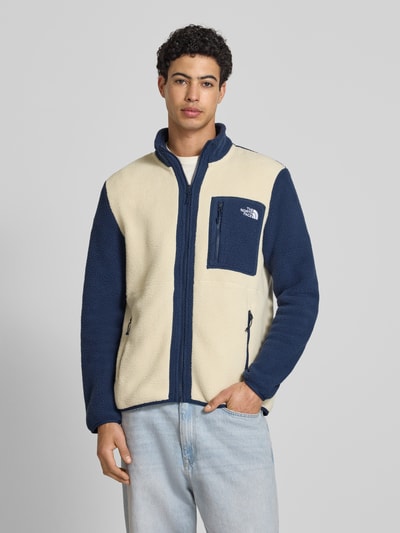 Männermodel trägt Fleecejacke mit Label-Stitching Modell 'Yumiori' von The North Face in Creme und Dunkelblau, Regular-Fit, Stehkragen, Reißverschluss, Reißverschlusstaschen, Rückenlänge 67 cm, Ärmellänge 70 cm, Ganzkörperansicht von vorne
