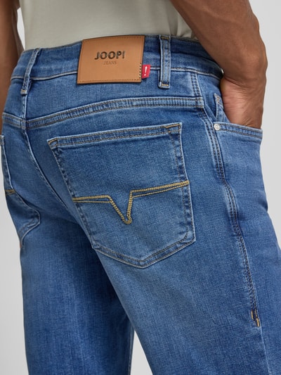 Männermodel draagt Modern Fit Jeans mit Eingrifftaschen Modell 'Mitch' van JOOP! in blauwe tint, mix van katoen en elastaan, detailaufnahme rug. Bundwijdte maat 32/32: 42 cm, binnenbeenlengte: 78 cm.