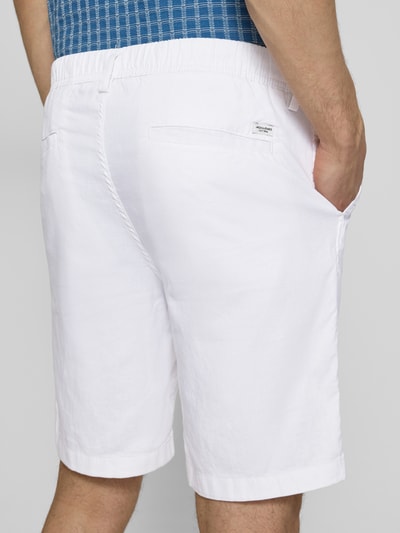 Männermodel trägt weiße Shorts mit Tunnelzug Modell 'JAIDEN' von Jack & Jones aus Baumwoll-Leinen-Mix, Regular-Fit, Ganzkörperansicht Rückansicht.