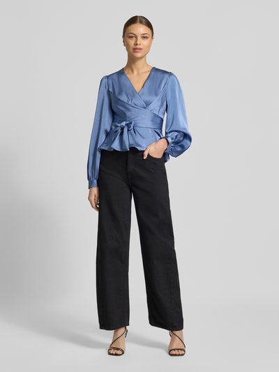 Frauenmodel trägt Regular Fit Bluse mit V-Ausschnitt Modell 'Rista' von Neo Noir in Blau, Wickel-Optik, Ganzkörperansicht von vorne.