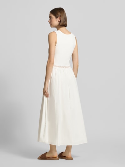 Frauenmodel trägt Midikleid mit Spitze Modell 'Nami' von OH APRIL aus Baumwoll-Viskose-Mix in Creme mit Taillierter Schnitt, Ganzkörperansicht Rückansicht.