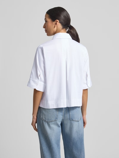 Modelka kobieca nosi Boxy Fit Bluse mit verdeckter Knopfleiste od Milano Italy, biały kolor, mieszanka bawełny ze stretchem, kołnierzyk koszulowy, długość tyłu w rozmiarze 36: 54 cm, długość rękawa w rozmiarze 36: 34 cm, widok całej sylwetki z tyłu.