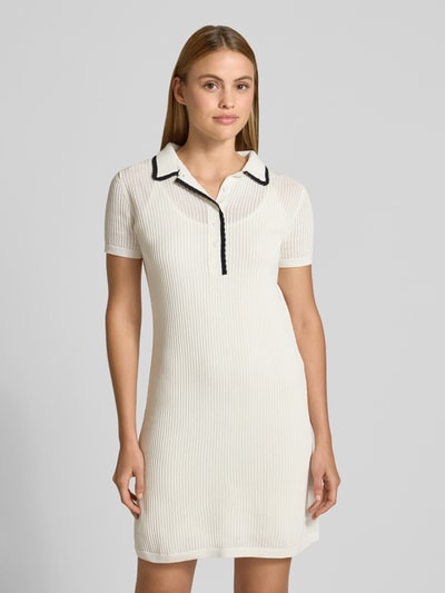 Frauenmodel trägt Slim Fit Minikleid aus reiner Baumwolle Modell 'SLYSY' von HUGO in Weiß mit schwarzen Kontraststreifen, Stricktextur, Nahaufnahme Oberkörper.
