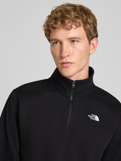 Männermodel trägt zwart Regular Fit sweatshirt met schipperskraag van katoenmix, logostitching, Model "EVOLUTION" van The North Face, Nahaufnahme oberkörper. Ruglengte maat M: 67 cm, mouwlengte maat M: 68 cm.
