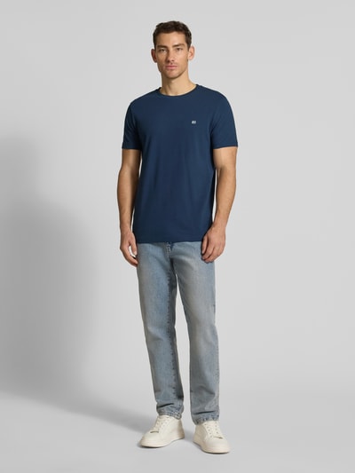 Männermodel trägt T-Shirt aus Baumwolle mit Rundhalsausschnitt von Christian Berg Men in Blau, Regular-Fit, Label-Detail, Ganzkörperansicht von vorne.