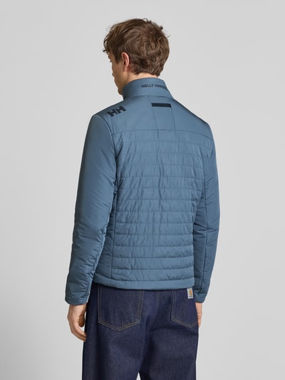 Männermodel trägt Regular Fit Jacke mit opstaande kraag en logoprint van Helly Hansen, steekzakken met ritssluiting, ruglengte 70 cm, rugaanzicht.