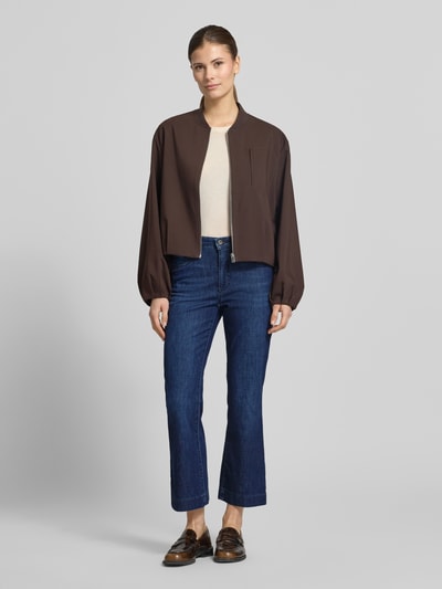 Frauenmodel trägt Bootcut Jeans im 5-Pocket-Design Modell 'Mary' von Brax aus Baumwoll-Mix mit Stretch-Anteil, Ganzkörperansicht von vorne.