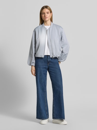 Kobiece modelka nosi Regular Fit Blouson mit Baseball-Kragen od Marc O'Polo, efekt: jednolity kolor, bufiaste rękawy, materiał recyklingowany, wpuszczane kieszenie, kształt kołnierza: baseballowy, zapięcie: zamek błyskawiczny, wykończenie: tunel, krój regular fit, długi rękaw, kolor jasnoszary, widok całej sylwetki z przodu.