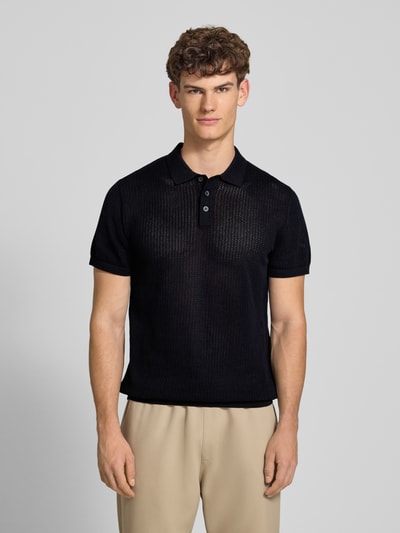 Männermodel trägt Modern Fit Poloshirt mit kurzer Knopfleiste Modell 'JESS' von Jack & Jones aus Baumwoll-Mix, semitransparentes Design, Polokragen, Farbe Schwarz, Rückenlänge bei Größe M 68 cm, Ganzkörperansicht von vorne.
