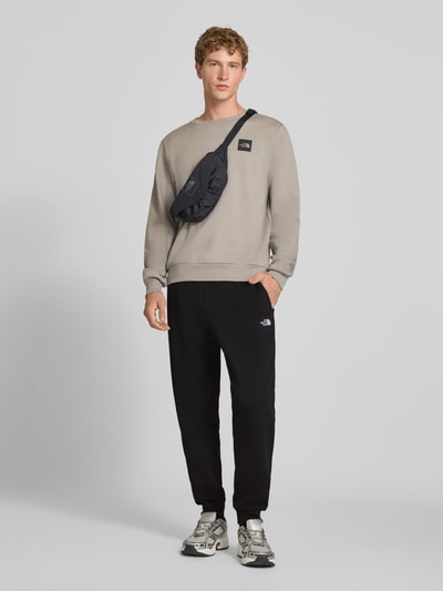 The North Face Spodnie dresowe o kroju relaxed fit z mieszanki bawełny model 'EVOLUTION' Czarny 1