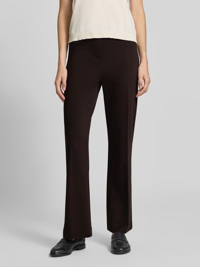 Frauenmodel trägt Schlaghose aus Viskose-Mix mit Bügelfalte von Rich & Royal, dunkle Farbe, elastischer Bund, Nahaufnahme Oberkörper. Damen Stoffhose mit Stretch-Anteil, Bootcut Fit, Bundweite S: 37 cm, Innenbeinlänge S: 73 cm.