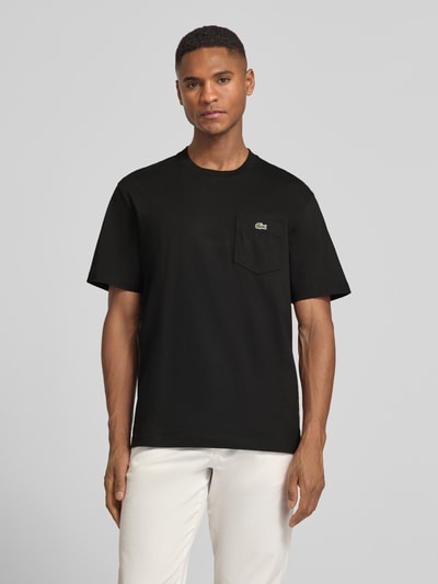 Männermodel trägt Regular Fit T-Shirt aus reiner Baumwolle von Lacoste, Optik: Unifarben, Logo-Stitching, Rundhals, Ganzkörperansicht von vorne.