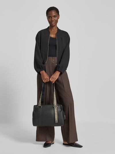 Frauenmodel trägt Shopper aus Baumwoll-Mix von CK Calvin Klein in Schwarz mit weißen Logo-Details, Ganzkörperansicht von vorne. Damen Shopper von CK Calvin Klein.