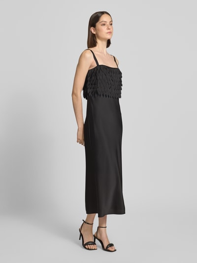 Frauenmodel trägt Midi-Trägerkleid mit Laser-Cut-Formen Modell 'DALASER' von BOSS in Schwarz, Satin, unifarben, Ganzkörperansicht von vorne.